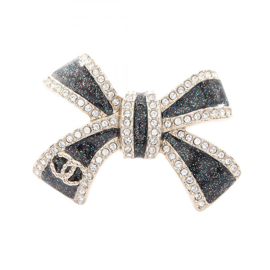 Chanel Coco Mark Ribbon Brooch with Gold-Plated Rhinestones, Available in Gold, Black, and Clear.